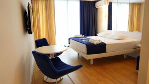 巴统Lux Apart Hotel 555的卧室配有1张床、1张桌子和1把椅子