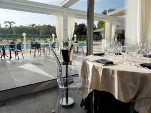 博洛尼亚博洛尼亚米切里诺菲恩拉酒店的一间带桌椅的餐厅和一个游泳池