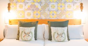 大加那利岛拉斯帕尔马斯Bed and Chic的一间卧室配有带枕头的床铺和墙壁