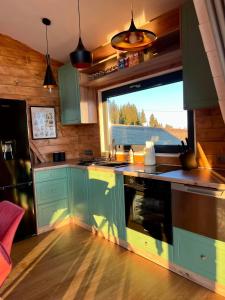 马里瑟尔Mokki的一个带绿色橱柜和大窗户的厨房