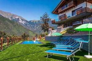 莱德罗Apartments in Pieve di Ledro/Ledrosee 22704的一个带椅子和遮阳伞的游泳池的度假酒店