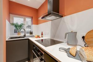 克利夫利斯Beach Apartment - 2 Bedrooms Free WiFi Parking的厨房设有橙色墙壁和水槽