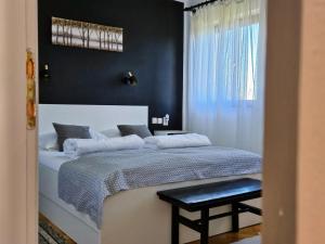 普利特维采湖Cozy House Zivko with Balcony的卧室配有一张白色的床和黑色的墙壁