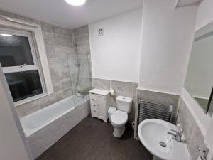 利物浦Liverpool city 5 bed house sleeps 12的浴室配有卫生间、盥洗盆和浴缸。