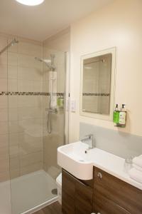 梅德斯通黑马旅馆的白色的浴室设有水槽和淋浴。