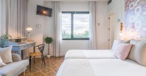 大加那利岛拉斯帕尔马斯Bed and Chic的一间酒店客房,配有一张白色的床和一张书桌