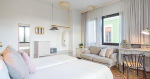 大加那利岛拉斯帕尔马斯Bed and Chic的白色卧室配有床、沙发和椅子