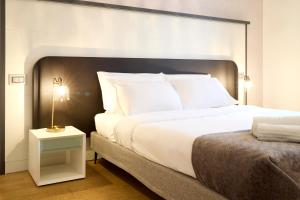米兰Milan Retreats Porta Romana的卧室配有一张白色的大床和床头柜。