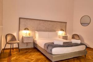 米兰Milan Retreats Porta Romana的一间卧室配有一张大床和两把椅子