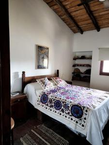 圣拉斐尔SANTA MARIA REINA的一间卧室配有一张带花卉棉被的床