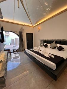 博帕尔The Whispering Palms Resort的一间卧室配有一张大床和一张桌子