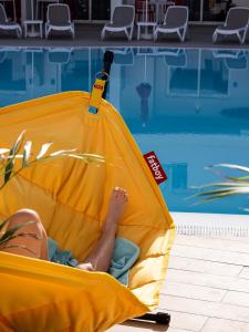 圣地亚哥港Sholeo Lodges Los Gigantes的躺在游泳池旁的黄木筏上的人