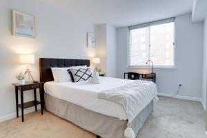 阿林顿Apartment Just Steps from Ballston Subway Station的卧室设有一张白色大床和一扇窗户。