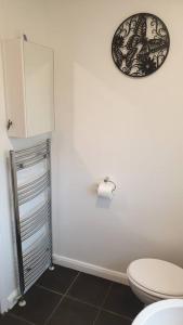 诺丁汉Entire house in Sherwood, Nottingham的一间带卫生间和墙上时钟的浴室