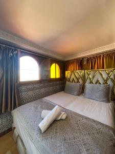 梅克内斯里亚德马拉克酒店的一间卧室配有一张带枕头的床
