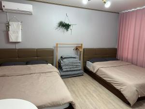 江陵市Sacheon Songlim的一间卧室配有两张床和镜子
