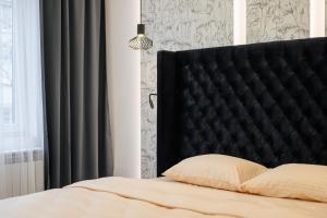 乌日霍罗德Luxury Apartments Laborca的卧室内一张带黑色床头板的床