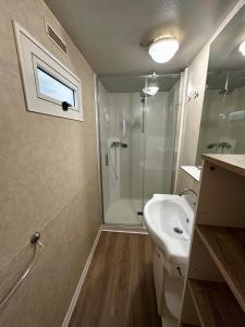 乌马格Kamp Slanik Mobile Homes的带淋浴和白色盥洗盆的浴室