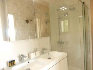 昂蒂布Chambre Bed and Breakfast dans villa的浴室配有盥洗盆和带镜子的淋浴