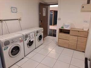 台中市台中朝圣行旅的洗衣房配有2台洗衣机和1个柜台