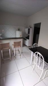帕尔马斯Stúdio Cozy的厨房配有桌子、两把椅子和冰箱
