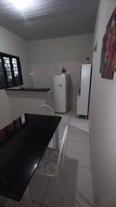 帕尔马斯Stúdio Cozy的厨房配有黑桌和冰箱。