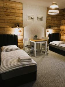 拉伊恰Gościniec Rajec的一间卧室配有两张床和一张桌子及椅子