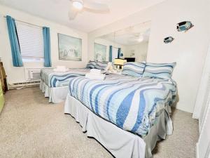 大洋城Stunning 2BR/2BA Bayfront Retreat的卧室内的两张床,配有蓝色和白色的床单