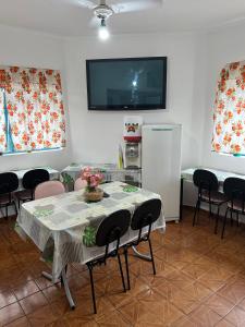 平达莫尼扬加巴Hotel Pousada Liberdade的一间带桌椅和电视的用餐室