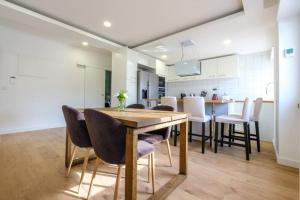 克卢什Apartamento T3 em Lisboa/ Queluz的厨房以及带木桌和椅子的用餐室。
