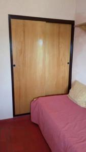 米拉玛Departamento a 200mts de la playa的一间卧室配有一张床和一扇木门