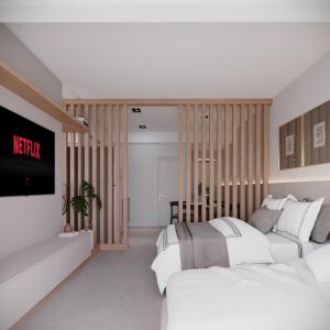 卡斯卡韦尔Edifício Master的一间卧室设有两张床,墙上配有电视。