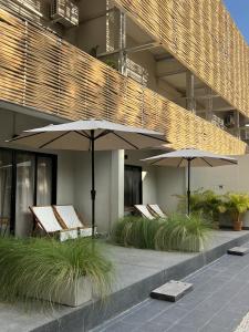 沙美岛Suncloud Hotel Koh Samet的大楼前的两把椅子和遮阳伞