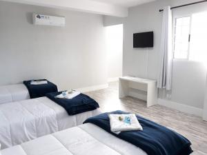 迈里波朗Pousada TOP的酒店客房设有两张床和电视。