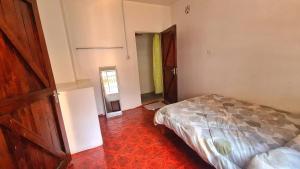 内罗毕Jabulani Nairobi Backpackers Hostel的一间卧室设有一张床和一个开放式门