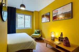 里昂Stella - 2 chambres-balcon- place de la République的卧室拥有黄色的墙壁,配有一张床和椅子