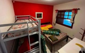 布拉干萨-保利斯塔Chácara Campo Verde的红色墙壁的客房内设有两张双层床。