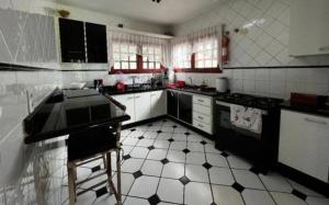 布拉干萨-保利斯塔Chácara Campo Verde的厨房铺有黑白瓷砖地板,配有电器