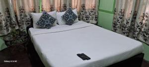 西隆Bloom inn的一间卧室配有一张带遥控器的床