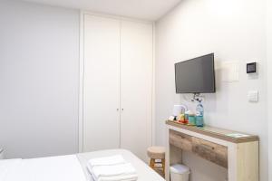 加亚新城Bella Gaia - Alojamento Local的一间卧室配有一张床,墙上配有电视