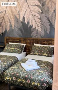 博洛尼亚B&B La Fenice的两张位于酒店客房的床,配有毛巾