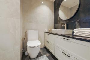 塔尔图Tähe Delux Apartment的浴室设有白色的卫生间和镜子