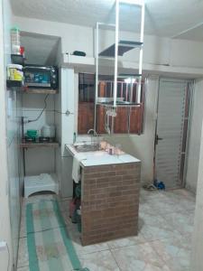 塞古罗港Mini Casa em Arraial d'Ajuda的厨房设有水槽和砖墙