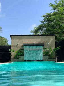 埃尔扎伊诺Tayrona Suites的一座房子前面带喷泉的游泳池