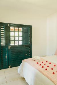 穆隆古Villa Nova Holanda的一间卧室,床上有红色玫瑰