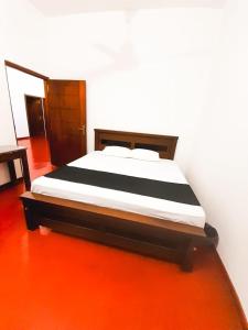 韦利格默VILLA AAA WELIGAMA的橙色地板的房间里的一个床位