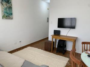 佩鲁伊比Apartamento Vista Mar的客厅配有桌子和平面电视。