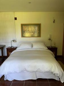 皮尔克Casa Los Ciervos的一张大白色的床,位于带两张桌子的房间