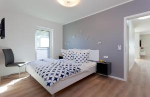 卡尔斯哈根Ferienwohnung Justus的白色卧室配有床和椅子