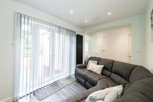 曼彻斯特Modern 4-Bed Retreat with Garden的带沙发和大窗户的客厅